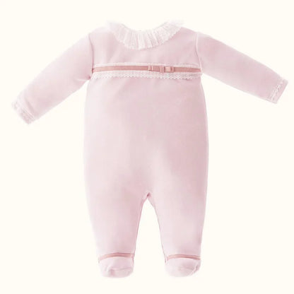 babygrow rosa para bebé com gola de renda e detalhe de laço, fundo neutro