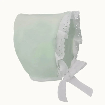 Touca de bebé verde claro com renda branca e laço, roupa confortável para recém-nascidos.