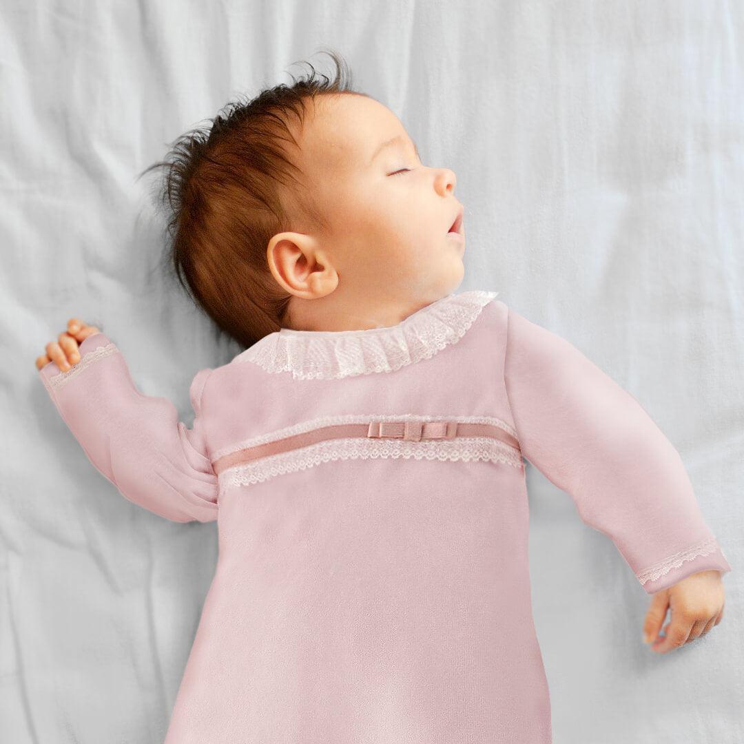 bebê dormindo com babygrow rosa de renda, roupa confortável para recém-nascido