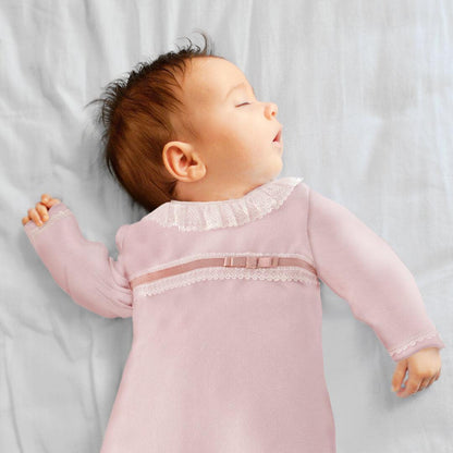 bebê dormindo com babygrow rosa de renda, roupa confortável para recém-nascido