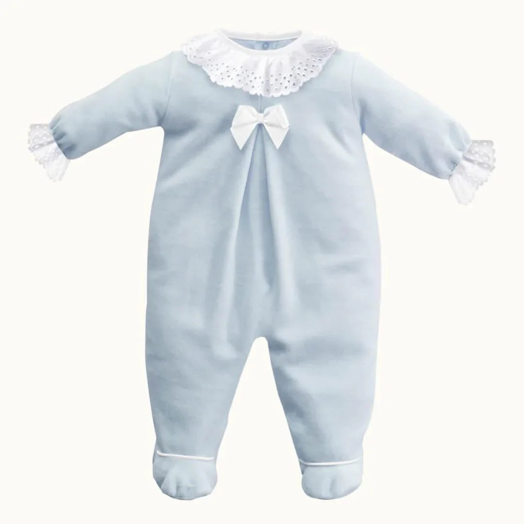 Babygrow azul de manga comprida com gola e punhos em renda branca, laço decorativo.