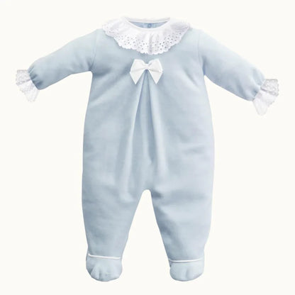 Babygrow azul de manga comprida com gola e punhos em renda branca, laço decorativo.
