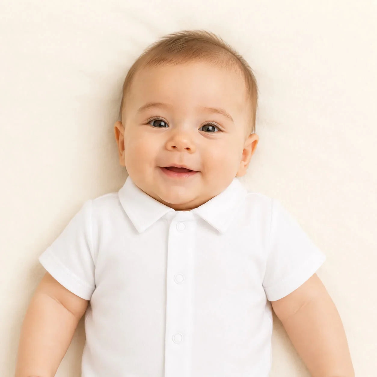Bebê sorridente usando body branco com gola, roupa confortável para recém-nascidos