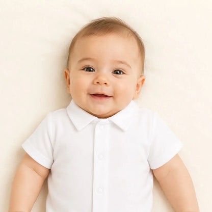 Bebê sorridente usando body branco com gola, roupa confortável para recém-nascidos
