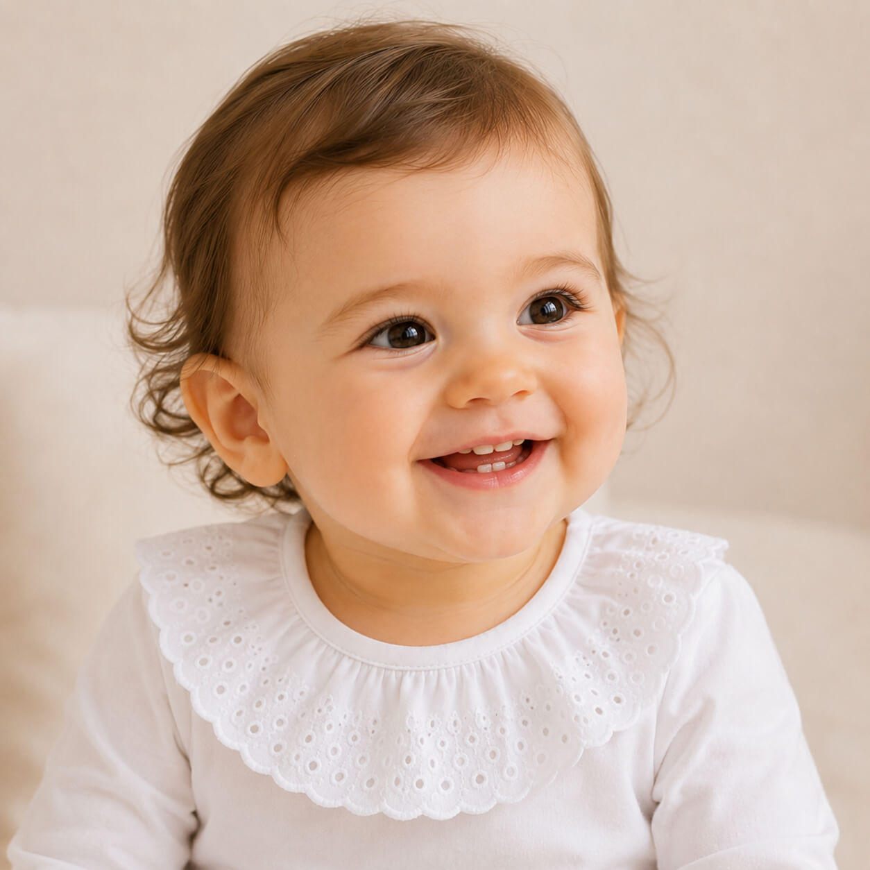 bebé  sorridente, vestida com body de gola bonny bordado inglês branco.