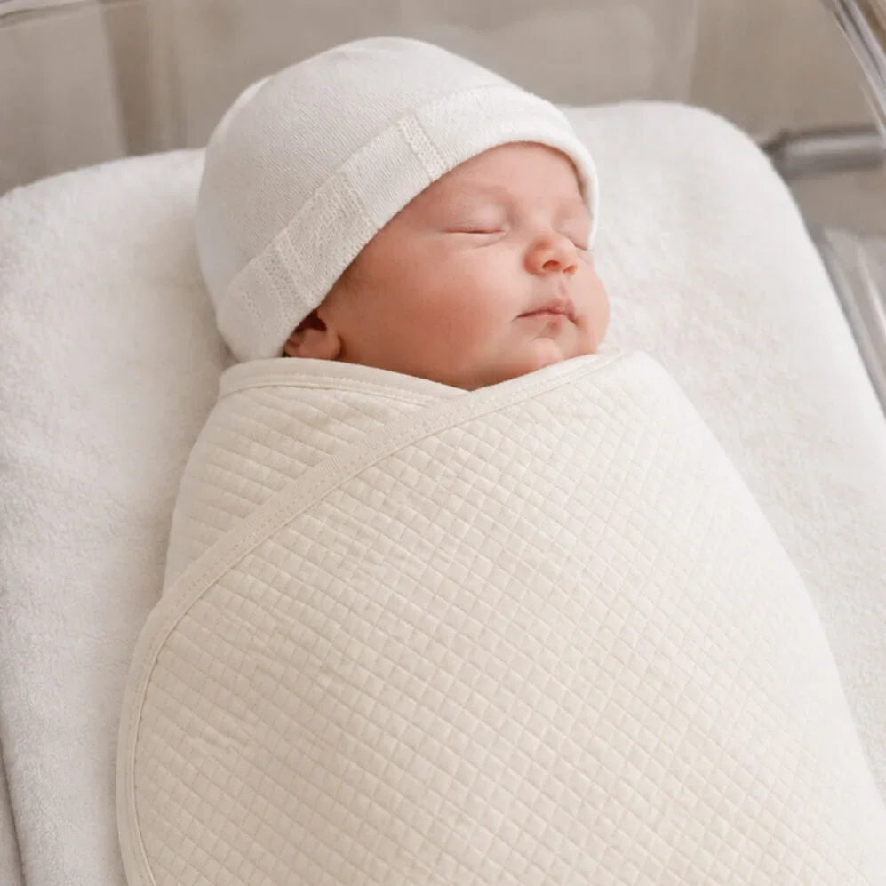 Bebé recém-nascido envolvido em manta macia com touca bege, ideal para para os dias mais frios