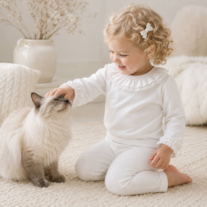 Bebé vestido com camisola com gola folho branco com renda branca em malha algodão, a brincar com um cão