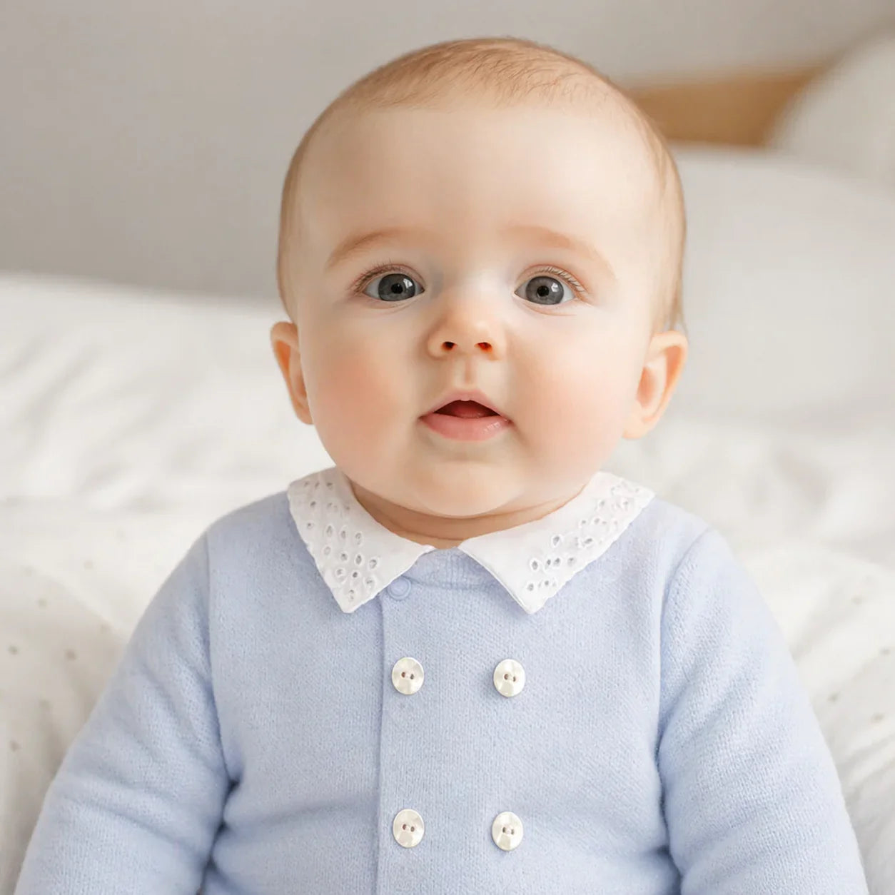 bebê vestindo babygrow azul claro com gola branca rendada, ideal para recém-nascidos