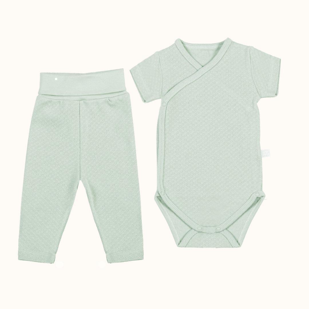 Conjunto de bebé verde claro com body de manga curta transpassado e calça sem pé, algodão macio.