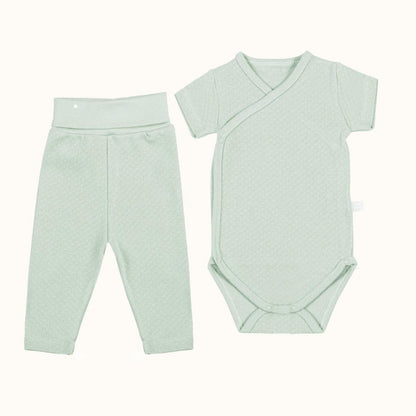 Conjunto de bebé verde claro com body de manga curta transpassado e calça sem pé, algodão macio.