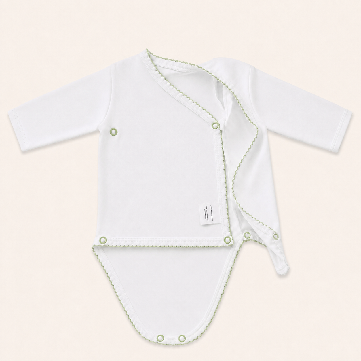 body cruzado bebe branco com verde, algodão super suave, a mostrar a posição a etiqueta de composição que não fica em contacto com a pele do bebé