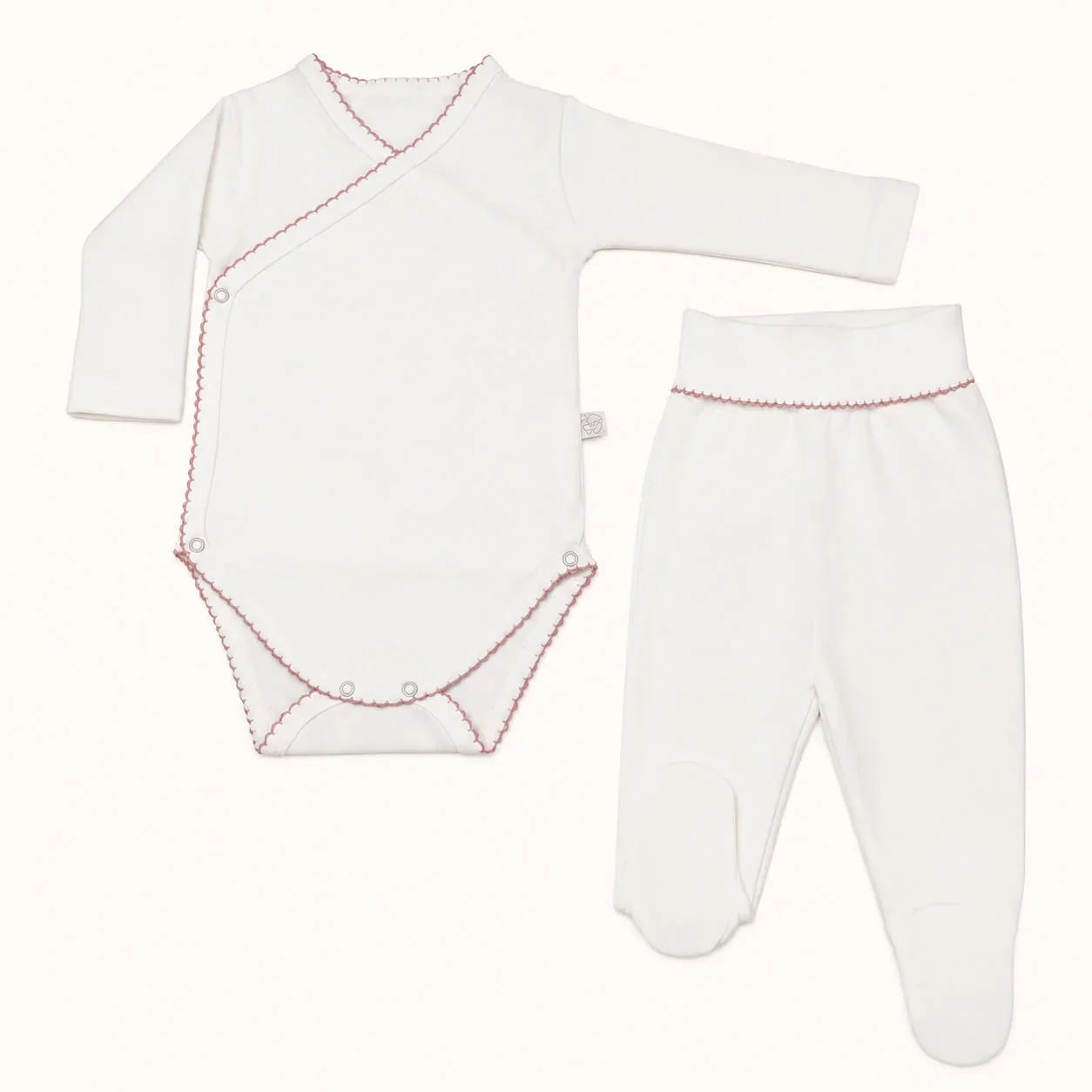 Conjunto de roupa de bebé branca com detalhes em rosa, ideal para recém-nascidos