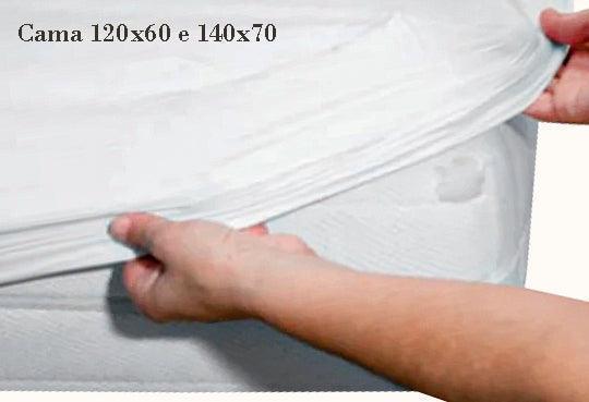 Capa protetora de colchão branco sendo colocada em colchão de berço, tamanhos 120x60 e 140x70.