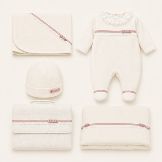primeira roupa para bebé bege com detalhes em laço rosa e renda, incluindo babygrow, gorro, manta, fralda e saco para a roupa