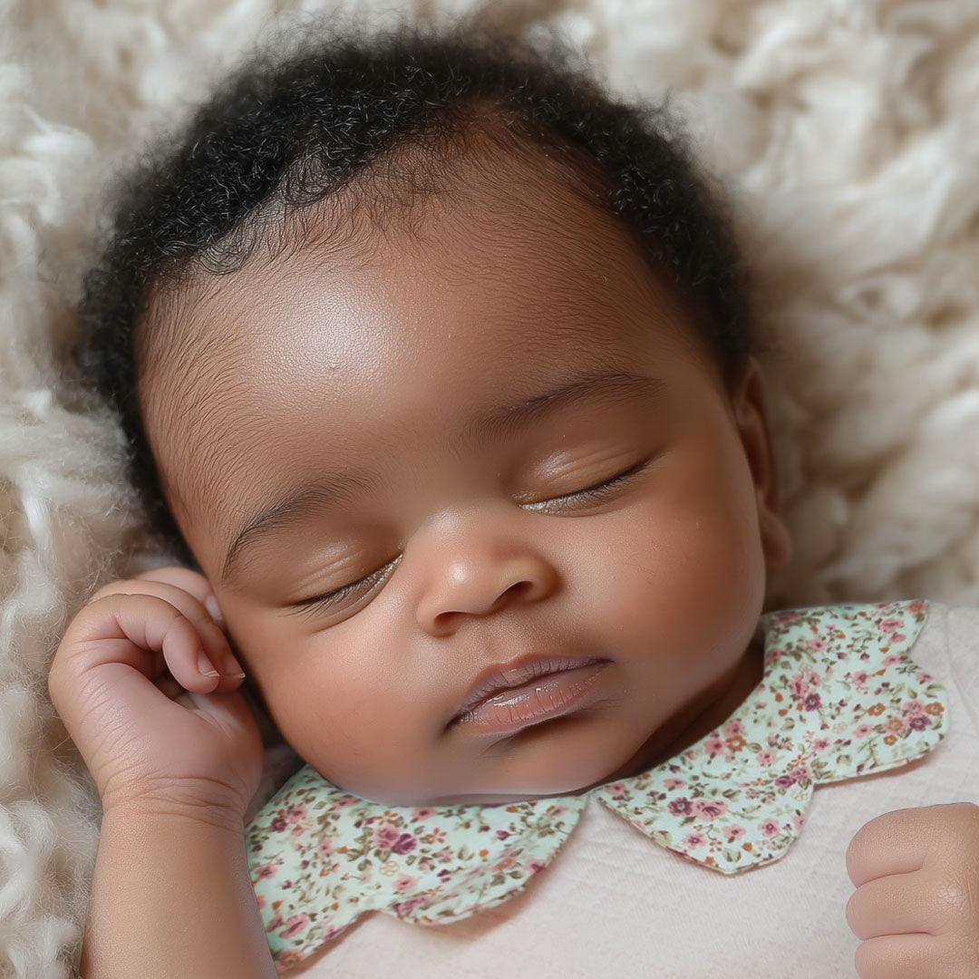 Bebê dormindo com body de gola floral, roupa confortável para recém-nascido