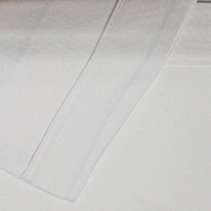 Conjunto de lençóis de malha branco em algodão para bebé, textura macia e confortável.