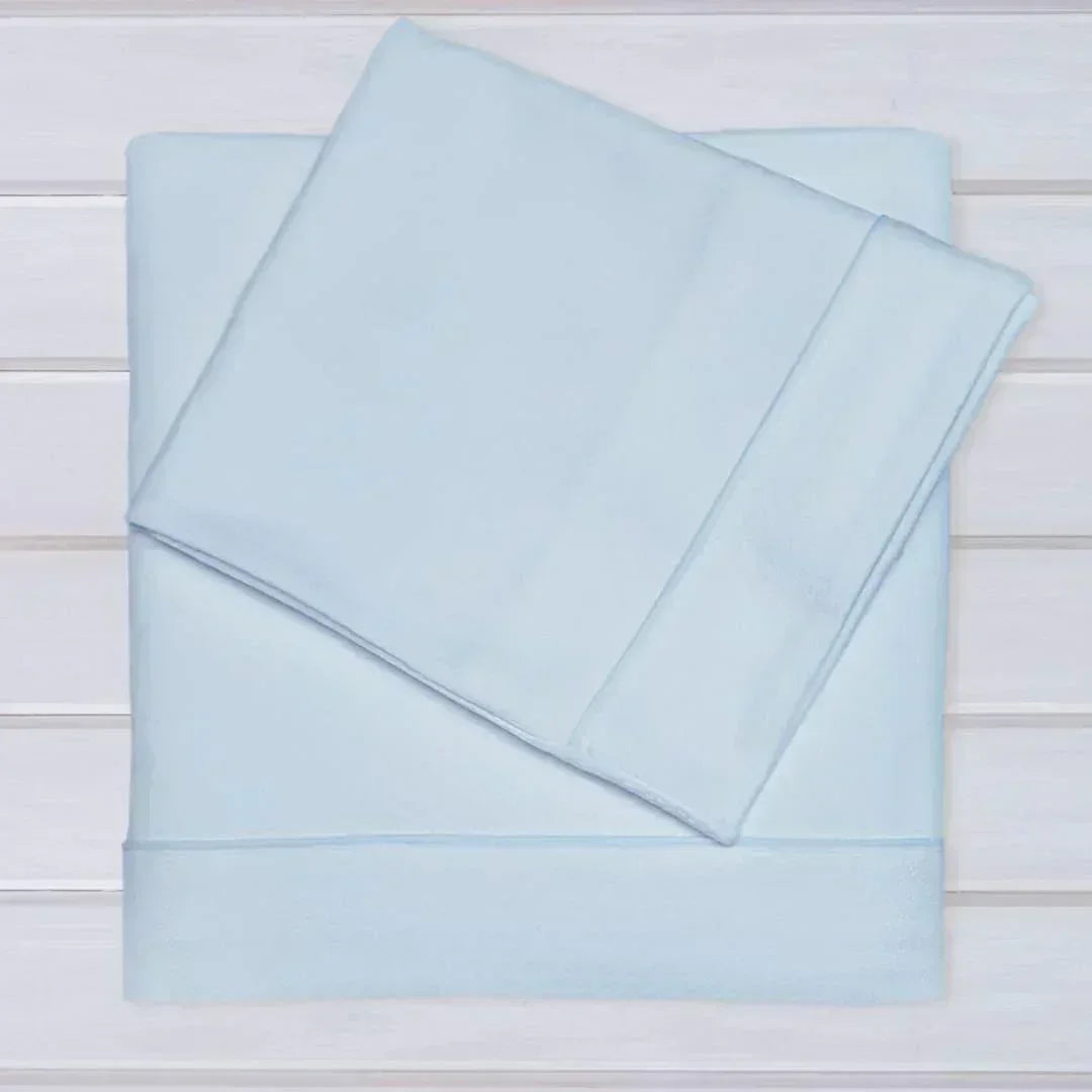 Conjunto de lençóis de malha azul claro para bebé, algodão, sobre superfície branca.