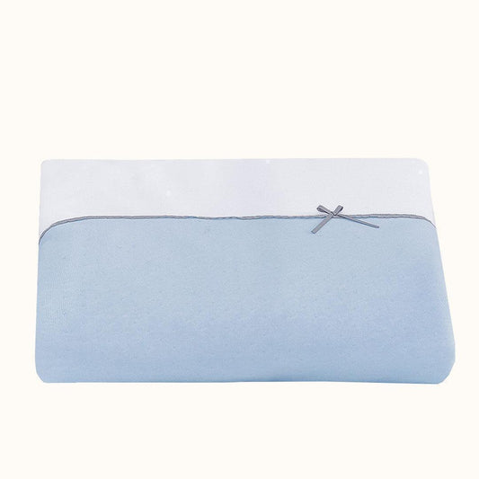 Lençol de berço azul e branco para bebé, com laço decorativo delicado.