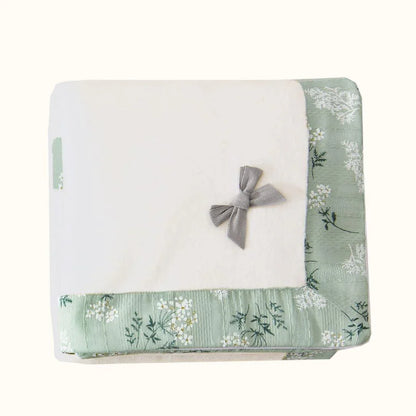 Manta de bebé branca com borda verde floral e laço cinza, enxoval delicado para recém-nascido.