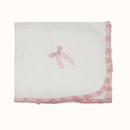 manta de bebê branca com laço rosa e borda floral, enxoval recém-nascido