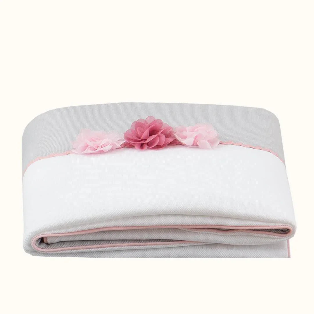 Manta de bebé branca e cinza com flores decorativas rosa, ideal para enxoval de recém-nascido.