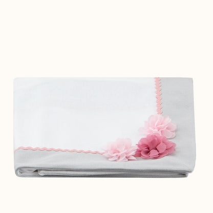 Manta de bebé branca e cinza com flores decorativas rosa, ideal para enxoval de recém-nascido.