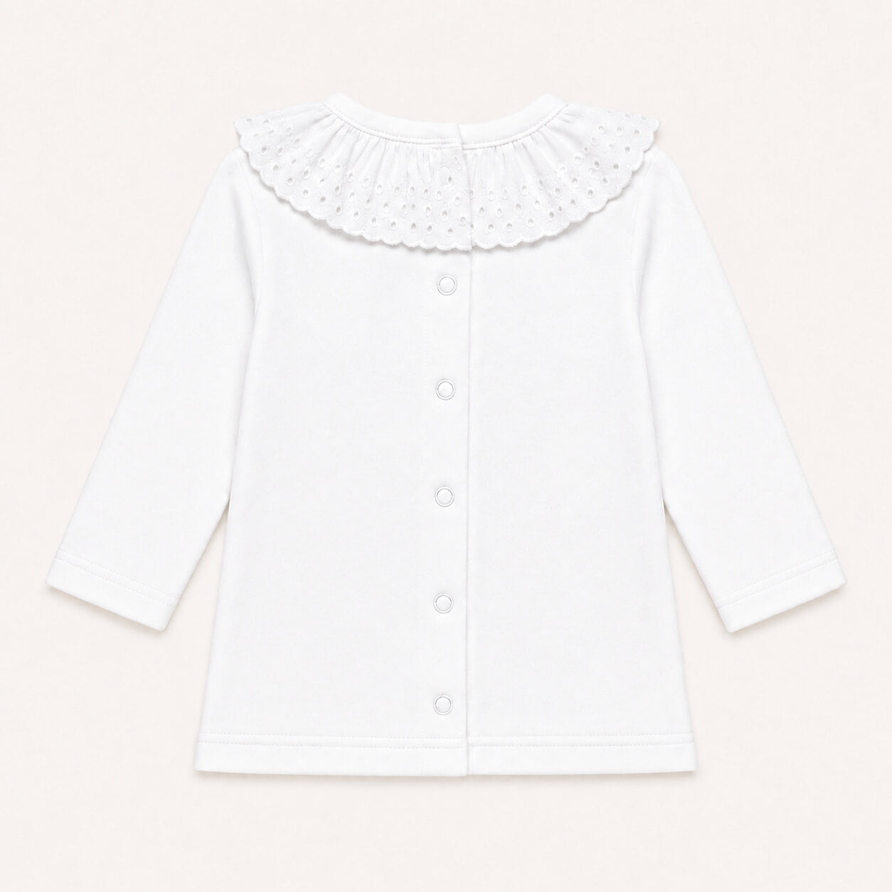 Costas de camisola de bebé branco com abertura de cima a baixo para facilitar a muda da roupa