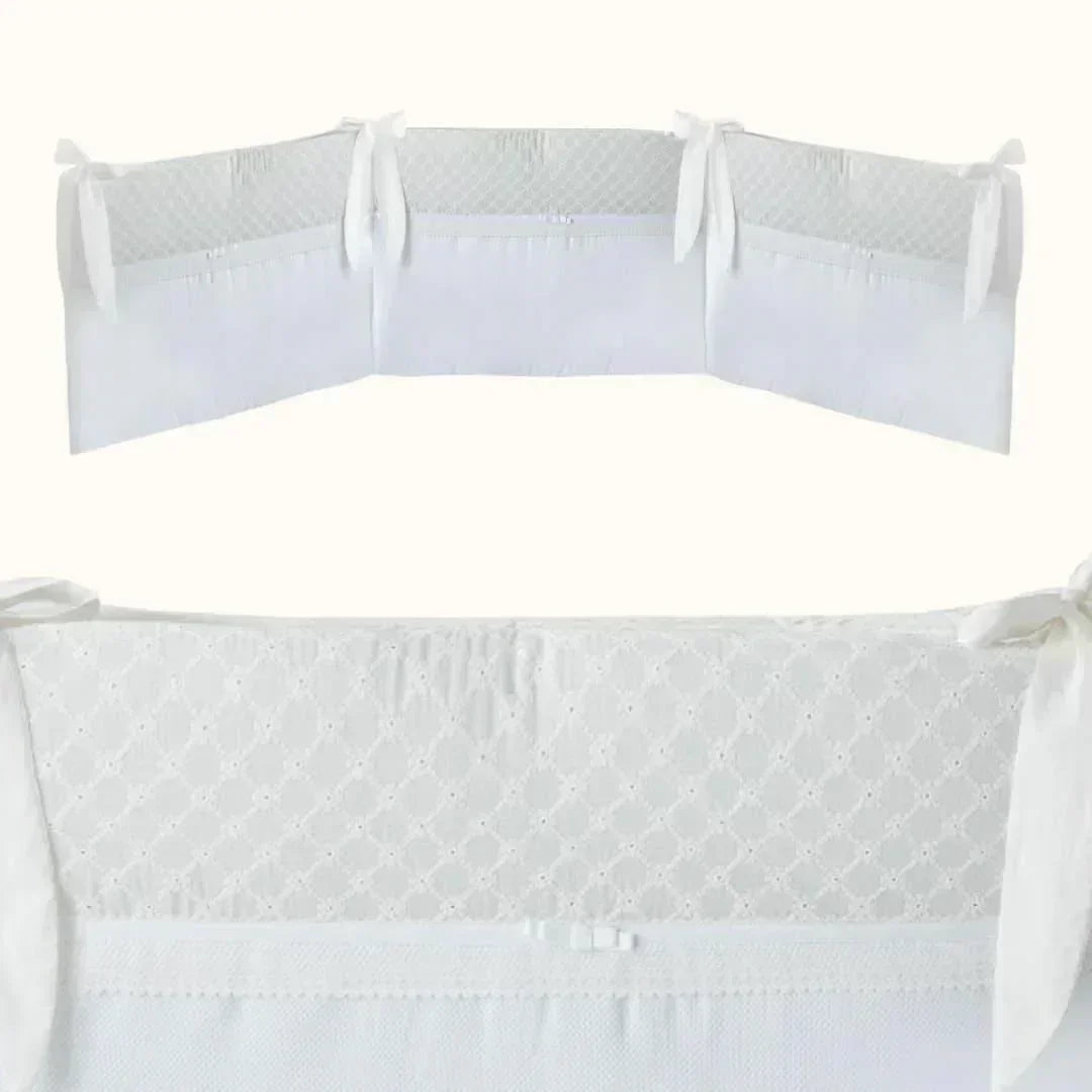 Resguardo de berço branco para bebé, com laços, bordado delicado e tecido macio.