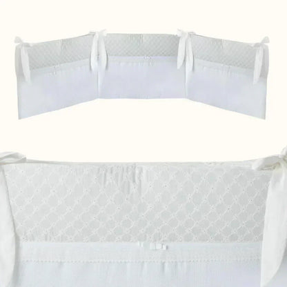 Resguardo de berço branco para bebé, com laços, bordado delicado e tecido macio.