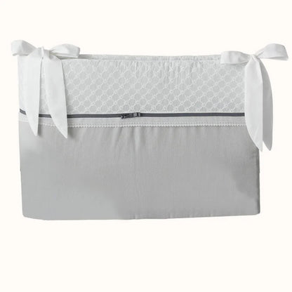 Resguardo de berço cinza com laços brancos e detalhe rendado, enxoval de bebé elegante.
