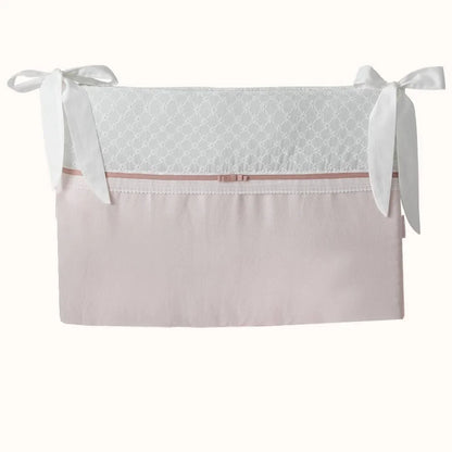 Resguardo de berço rosa e branco com laços decorativos, tecido delicado para bebé.