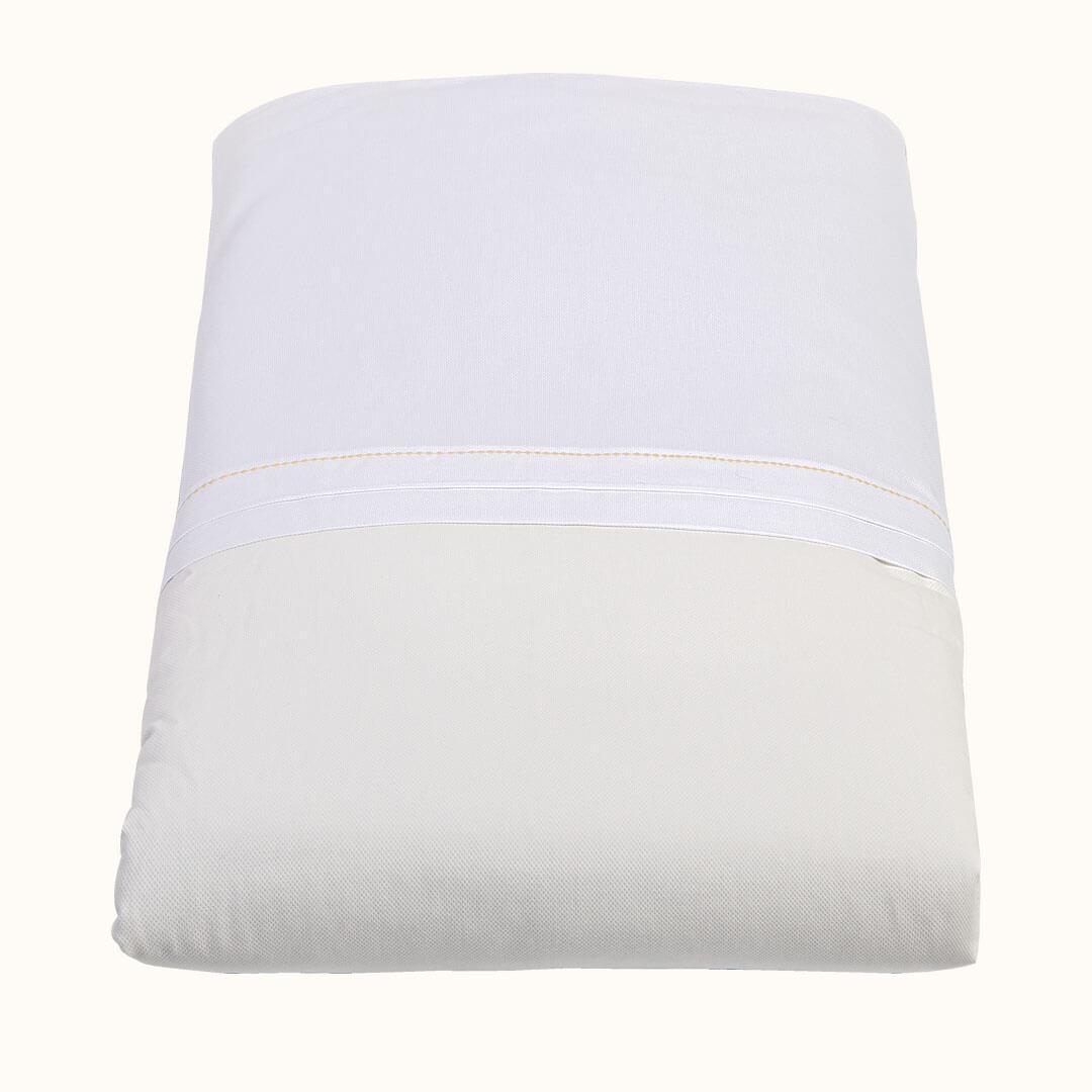 Edredão de bebê bege e branco, macio, ideal para berço de recém-nascido.