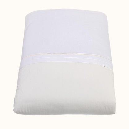 Edredão de bebê bege e branco, macio, ideal para berço de recém-nascido.