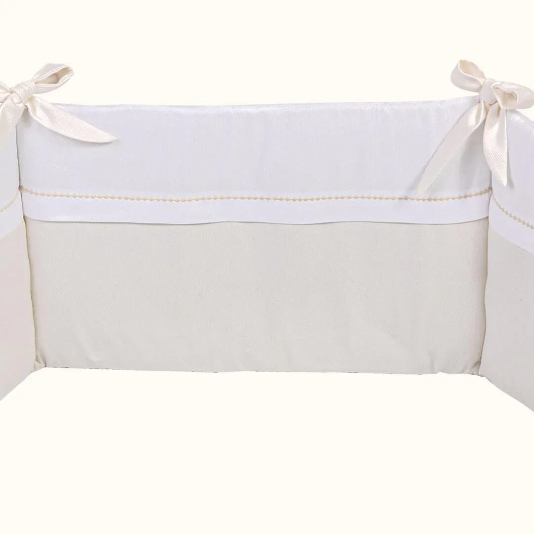 Resguardo de berço bege e branco com laços, ideal para enxoval de bebê