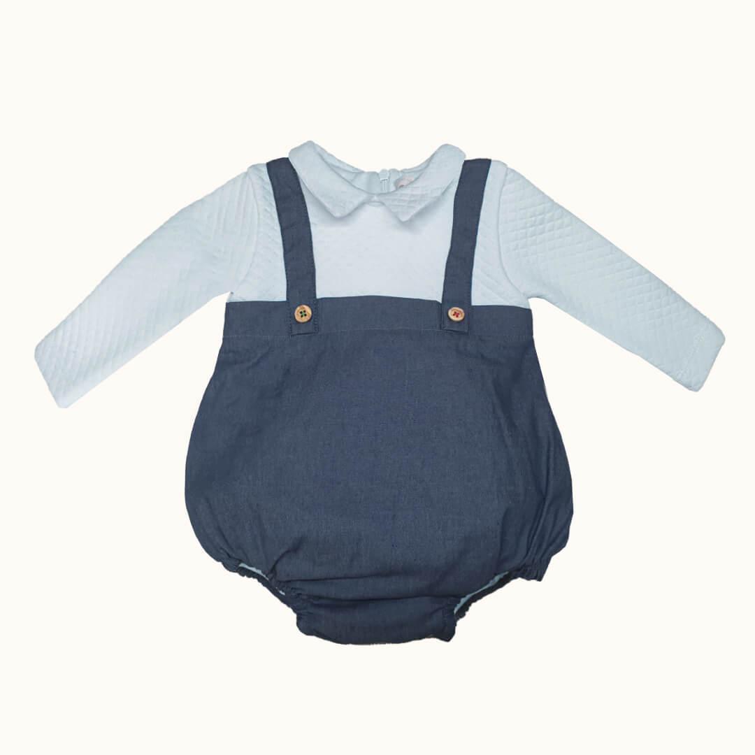 Fofo denim azul para bebé com alças e botões, sobre body branco de manga comprida.