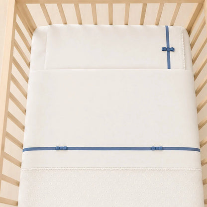 Berço com lençóis romantic bege com fita e laços azul, composto por lençol de cima, lençol capa e fronha. Popeline 100% algodão com tratamento anti-pilling.