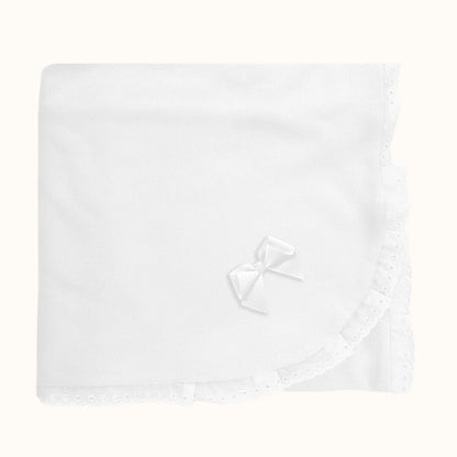 Manta de bebê branca com renda delicada e laço, ideal para enxoval de recém-nascido.