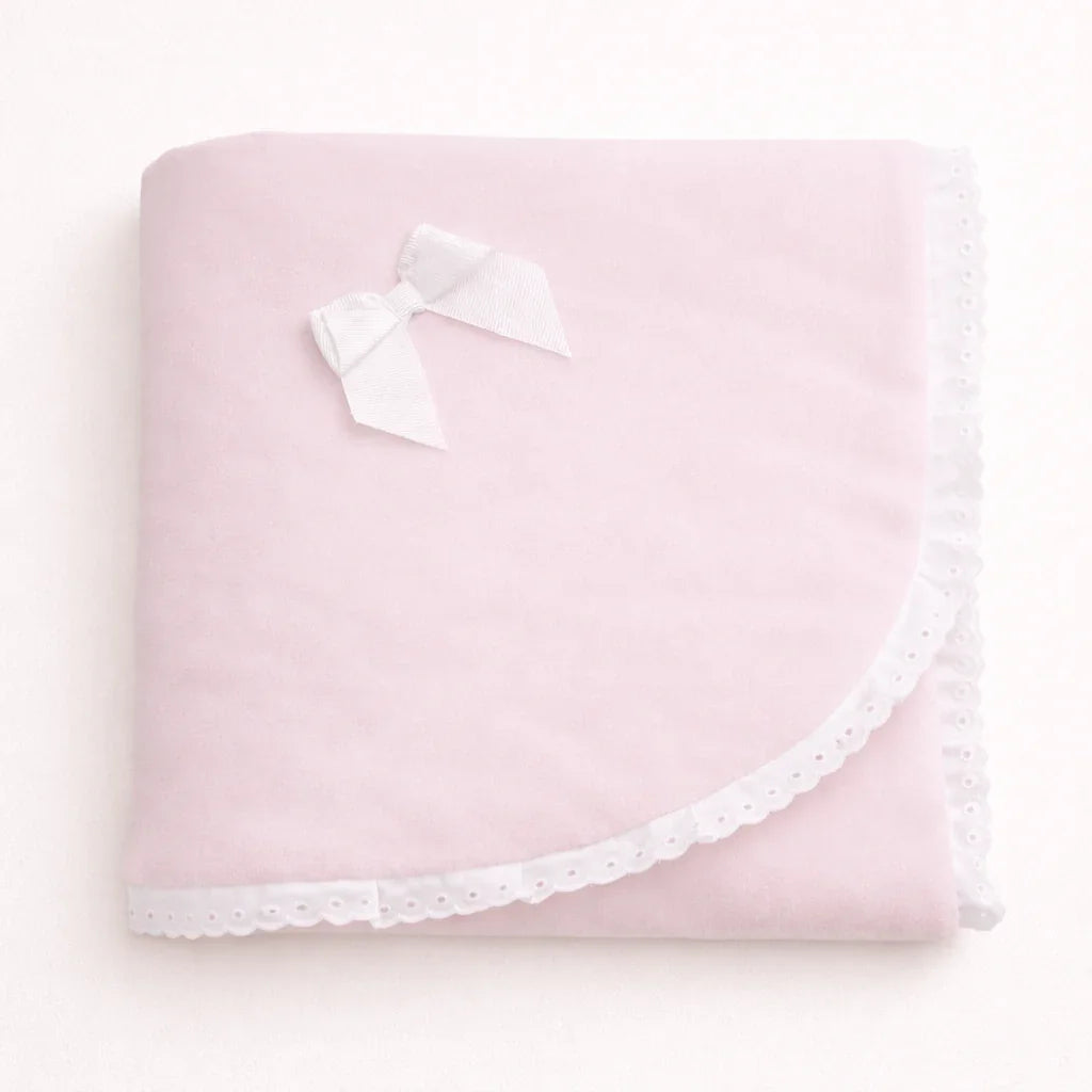 Manta de bebê rosa clara com laço branco e acabamento delicado em renda