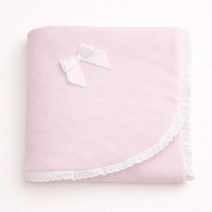 Manta de bebê rosa clara com laço branco e acabamento delicado em renda