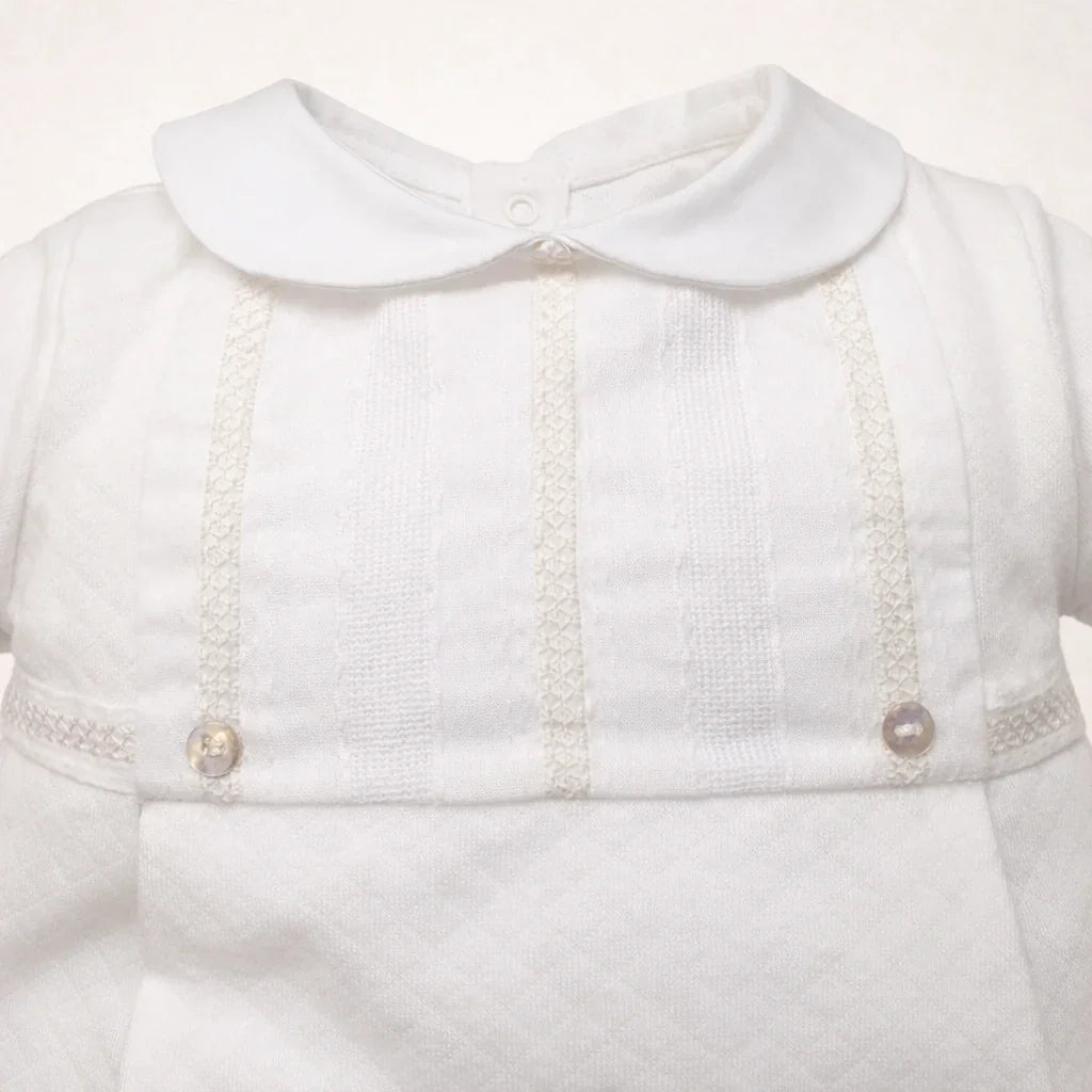 detalhe de babygrow bege com gola redonda e detalhes bordados e botões, super delicado e glamoroso