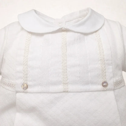 detalhe de babygrow bege com gola redonda e detalhes bordados e botões, super delicado e glamoroso