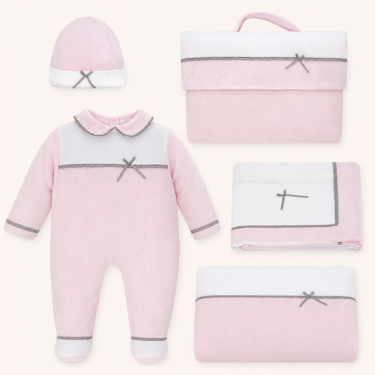 Conjunto primeira roupa de bebé rosa e branco com laços, incluindo macacão, gorro e acessórios.
