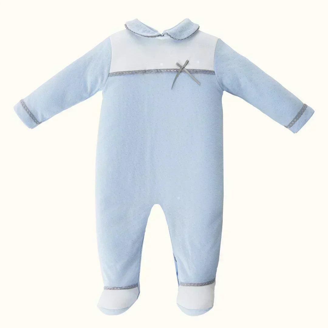 Babygrow azul de manga longa para recém-nascido, com gola e laço decorativo.