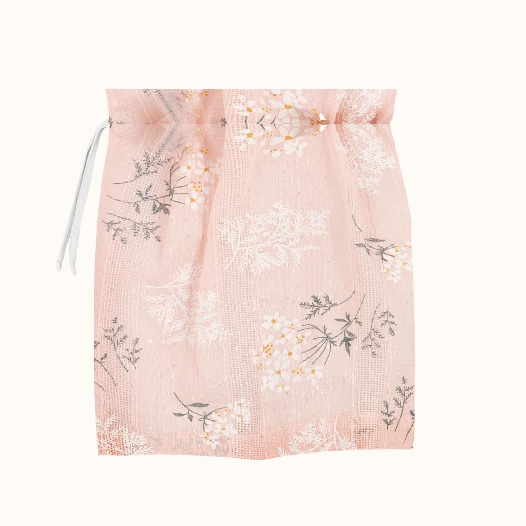 Saco organizador de musselina rosa com estampa floral delicada para enxoval de bebê.