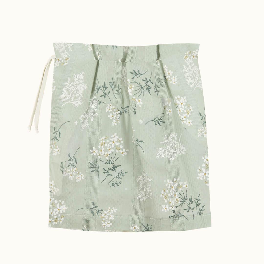 Saco para roupa de bebê verde claro com estampa floral delicada.