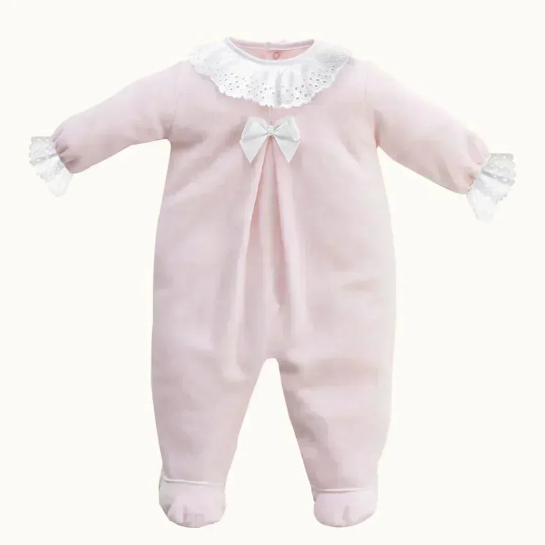 macacão de bebê rosa com gola e punhos rendados brancos, laço decorativo no peito