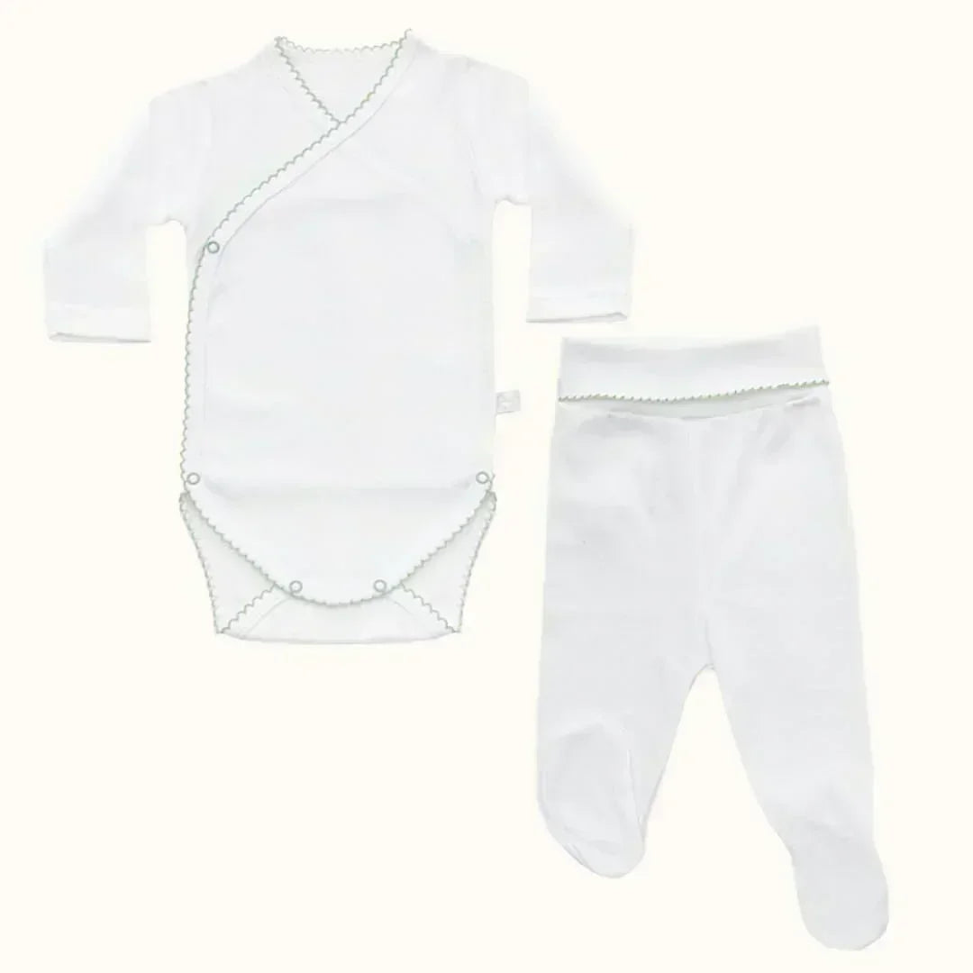 Conjunto de primeira roupa para bebé em algodão branco com detalhes verdes, body e calça.