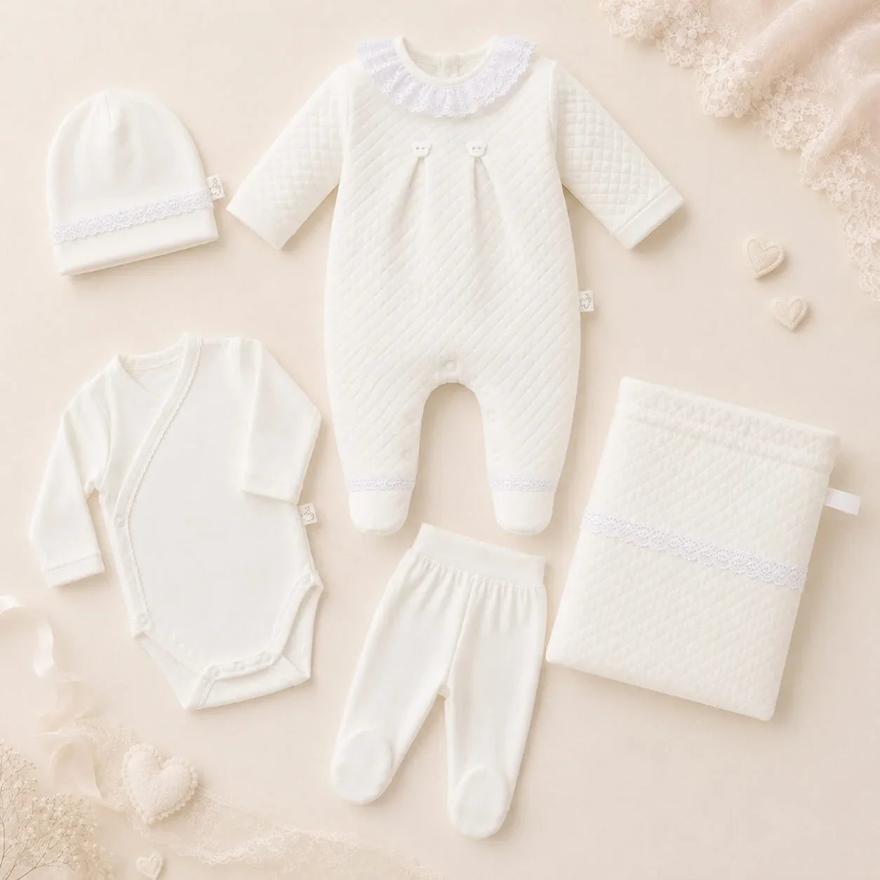 Conjunto de roupa de bebé bege com detalhes em renda, ideal para recém-nascidos, composto por babygrow, body, calças, gorro e saquinho para guardar tudo