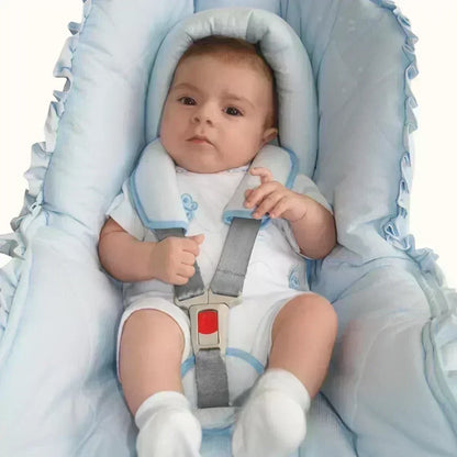 Bebê em assento infantil com redutor e protetores de cinto azul, conforto e segurança
