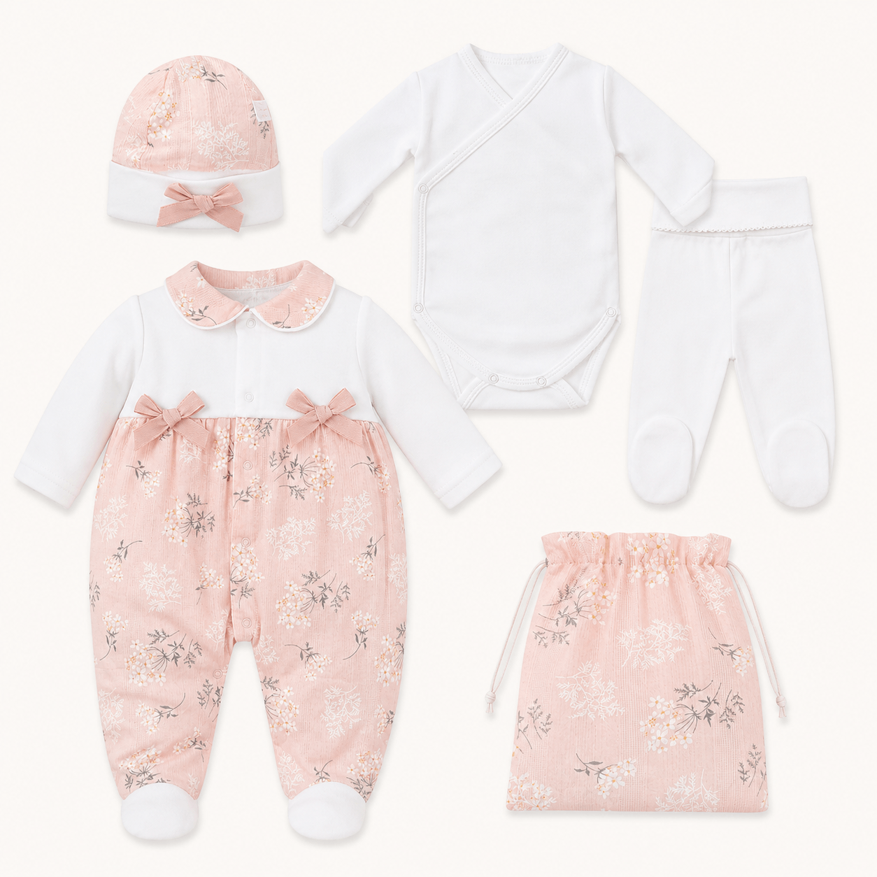 Conjunto enxoval de bebê menina com estampas florais rosa, macacão, body, calça, touca e saquinho.